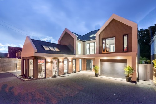 Lake Billericay New Build Contemporary Home Dusk view soft timber detailing White render