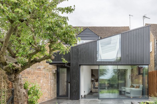 Mill Lane Stock Contemporary Extension vaulted glazed gable end black timber cladding frameless glass single entrance sidling door