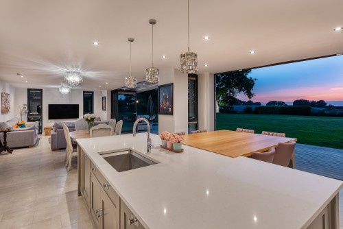 North Tye Swanley New Build Contemporary Home corner front view grey stone cladding timber cladding white render open plan family room kitchen island diner bifold doors